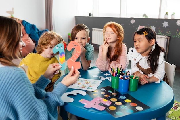 Children joyfully playing with colorful building blocks in a bright classroom environment.