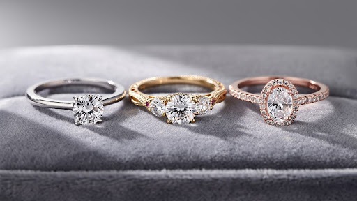 Engagement rings placed on soft fabric background.