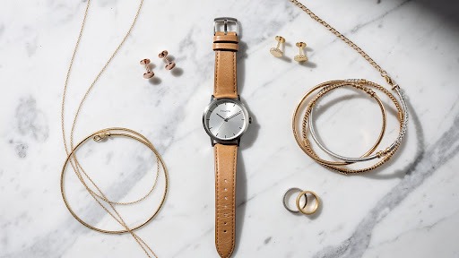 Minimal jewelry flat lay with watch and rings.